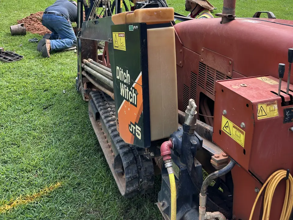Ditch Witch JT5 mid-bore on a residential lawn in Greenville County, SC with the crew tracking the drill head